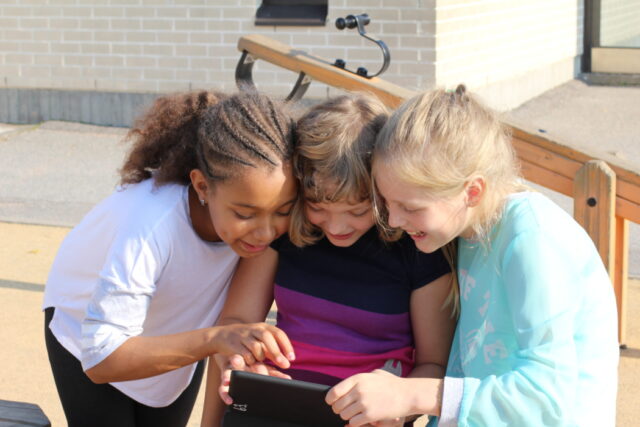 school children looking at a tablet