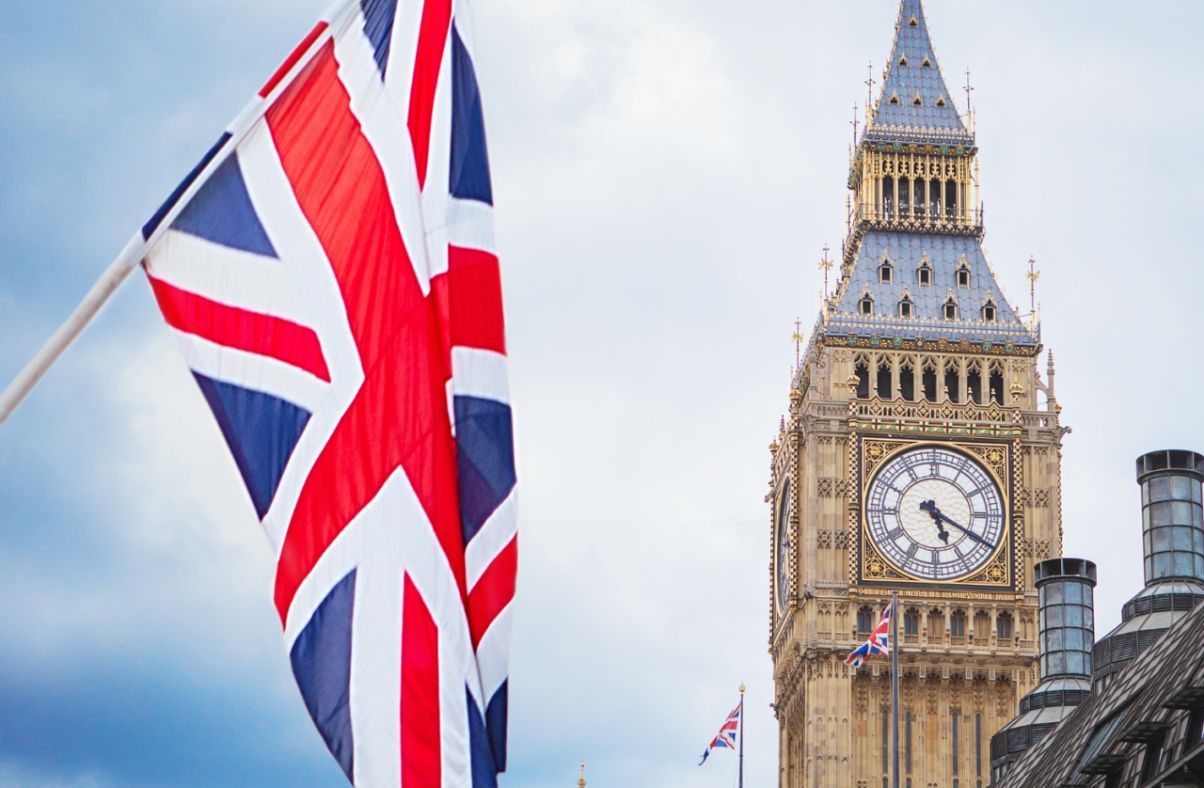 Union Jack flag flying in front of Big Ben's clock tower in London, United Kingdom.