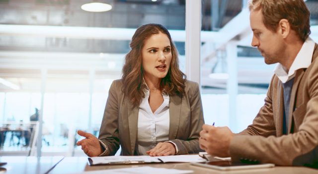 Manager and employee discussing salary transparency and pay decisions during a workplace meeting.
